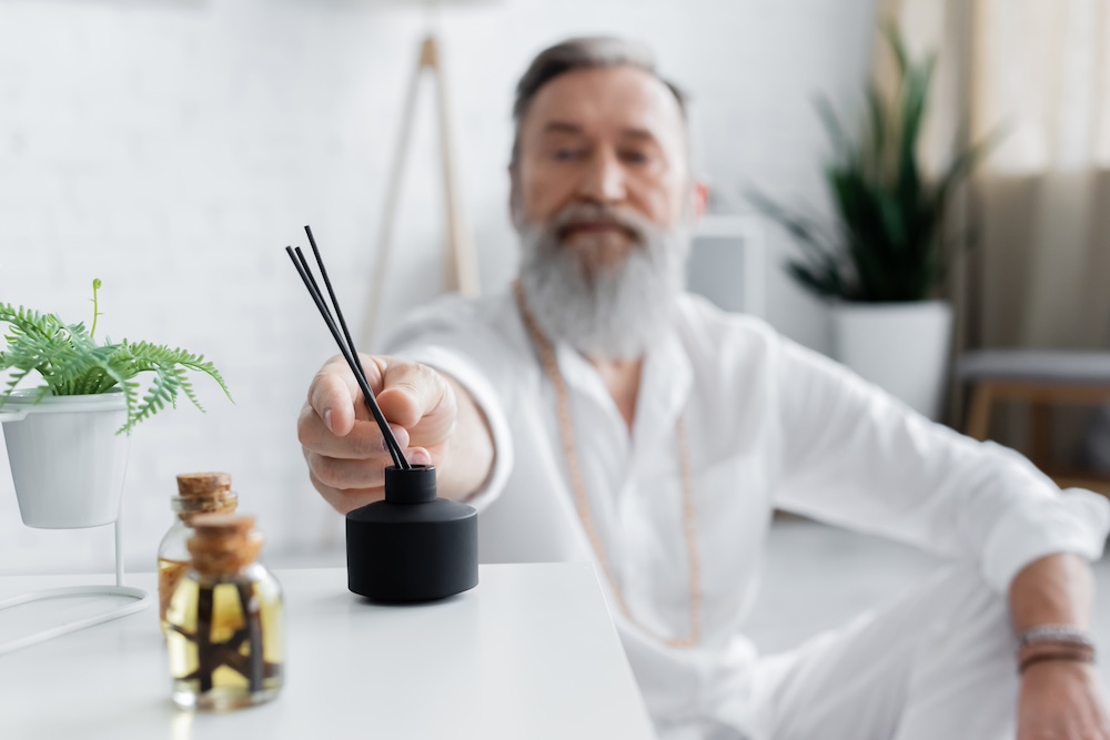 A senior memory care community resident using an oil diffuser