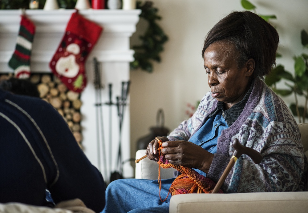 A resident of one of the best memory care communities knitting during the holidays