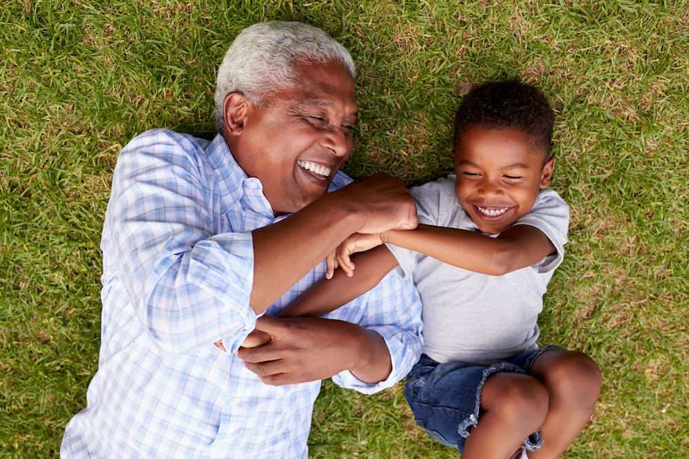 A resident of our dementia care community and his grand son play outside together