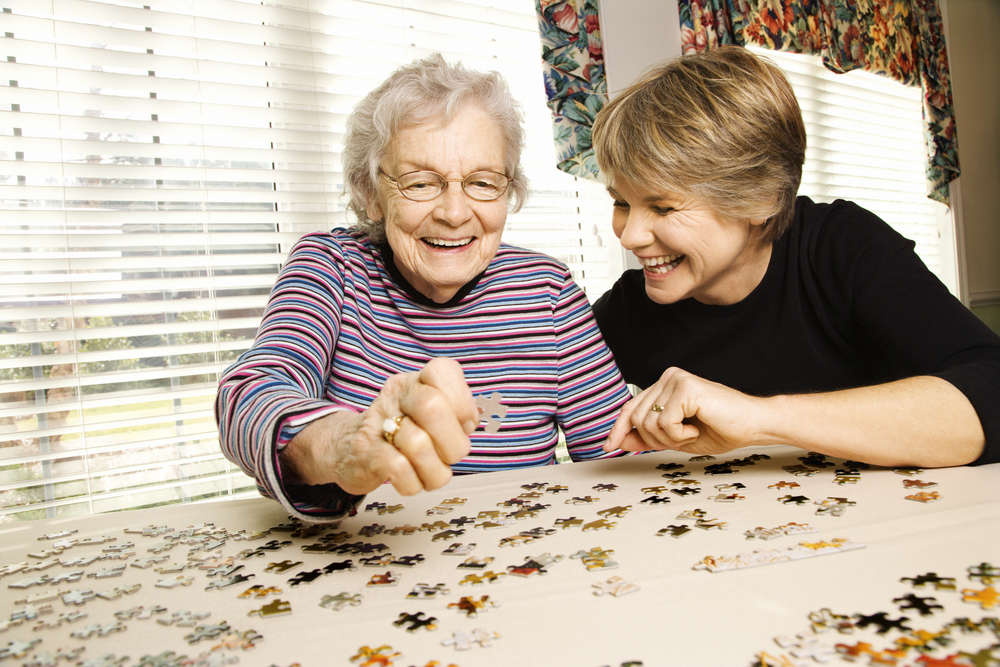 Senior woman solving a puzzle in memory care near me.