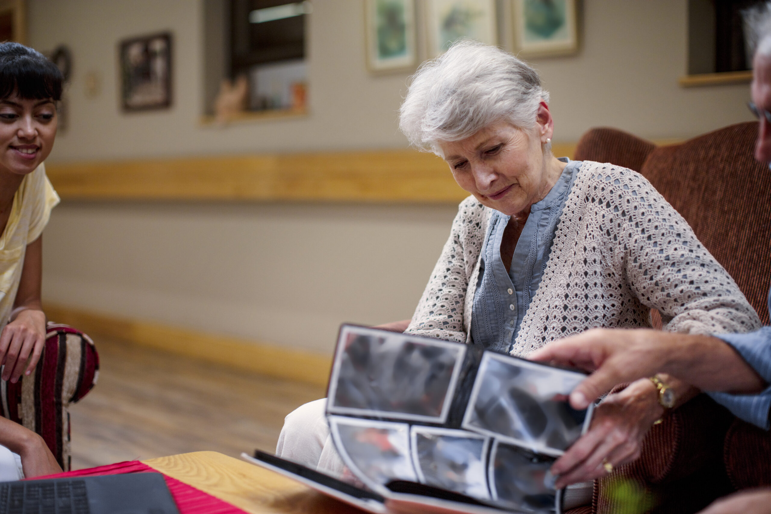 Woman looking at photos in assisted living with memory care.