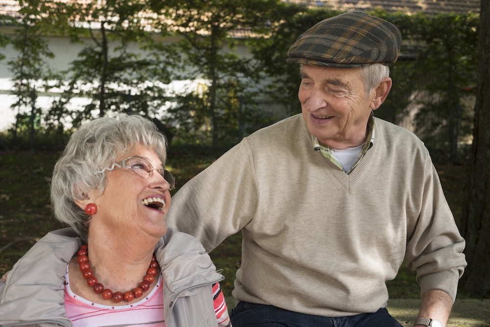 Senior couple sharing a joyful moment together outdoors at best memory care communities